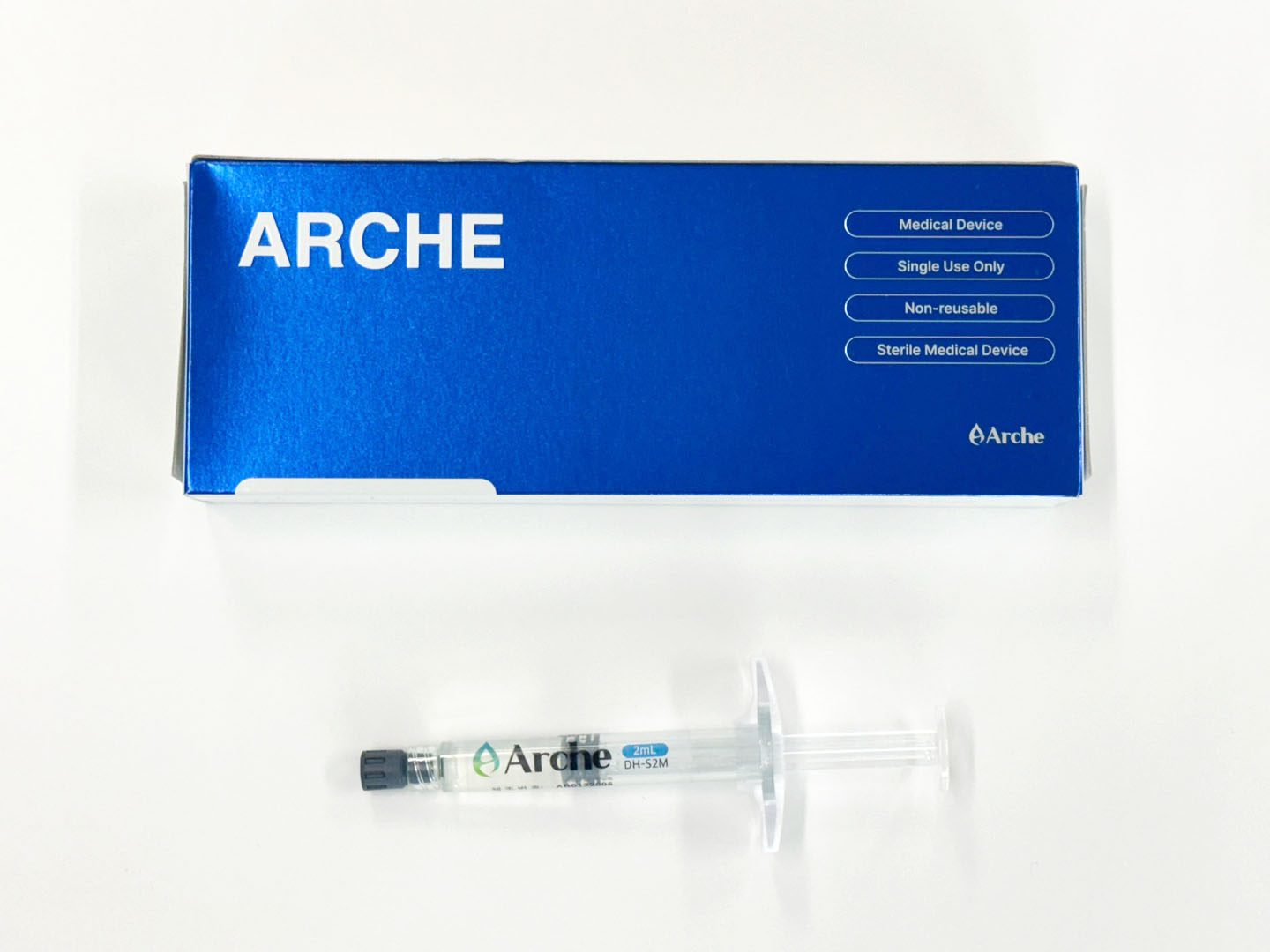 alt="blue box of arche scalp treatment for hair recovery with syringe of 3ml of arche gel"